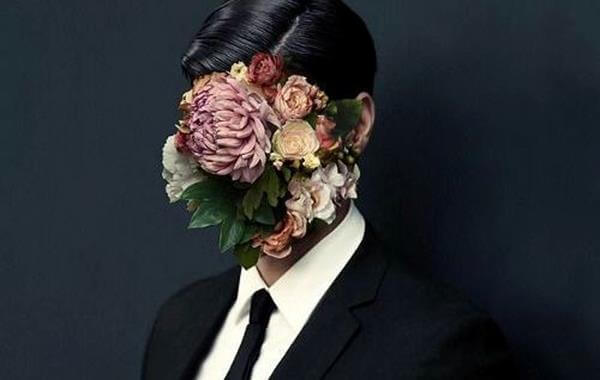 mann med blomster som dekker ansiktet