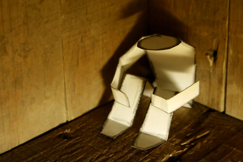 paper man sitting in a corner