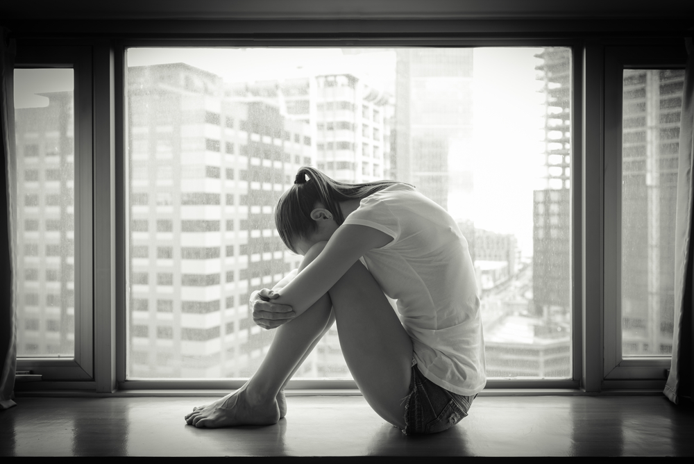 Woman Curled Up In Front Of Window