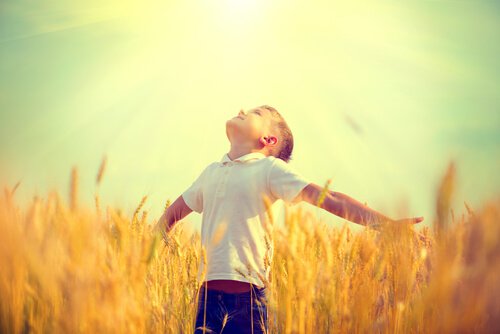 boy-with-his-arms-open-looking-at-the-sun