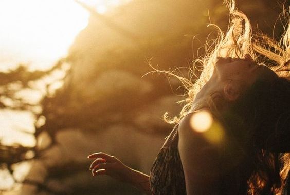 woman-looking-up-hair-blowing-in-wind