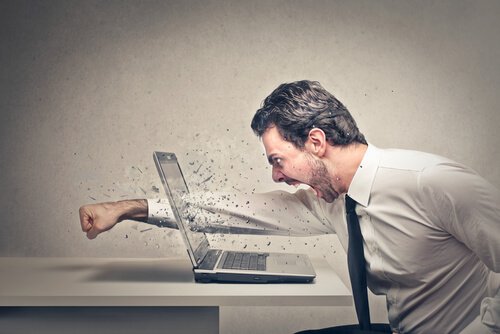 angry man punching through a laptop screen