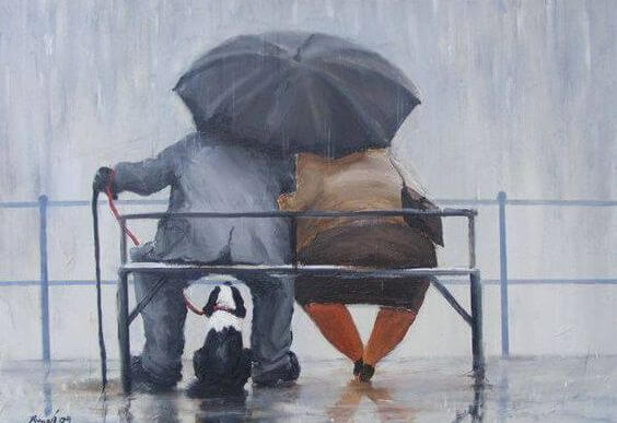 people on bench with umbrella