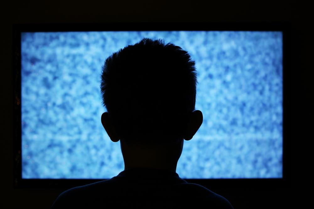 child in front of static tv