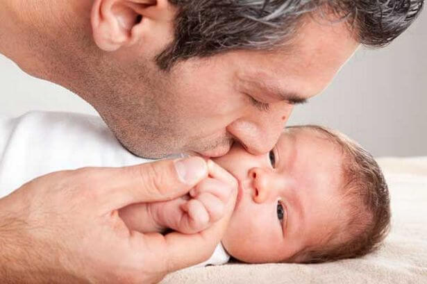 father kissing son