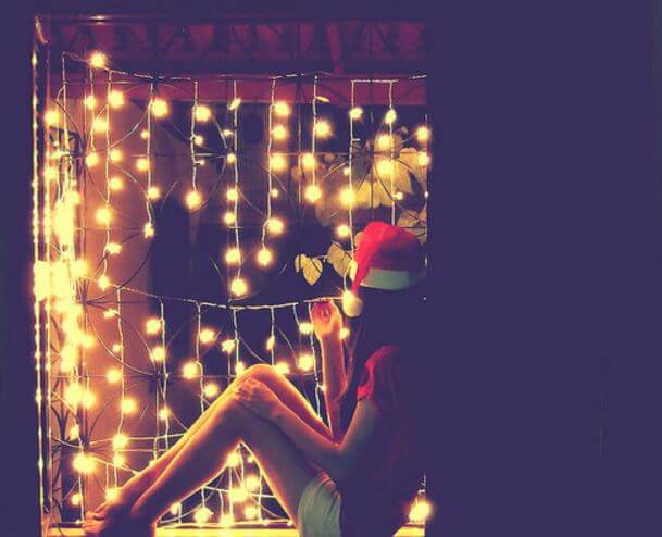 girl with santa hat and string lights