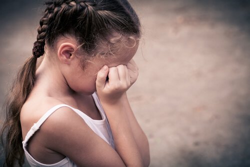 little girl covering face