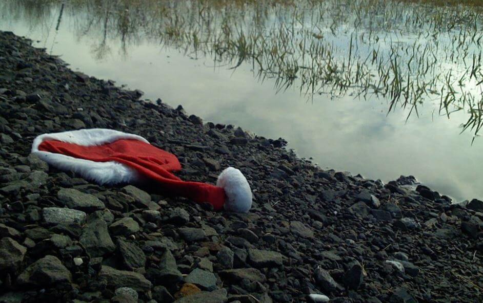 santa hat on the ground by a river