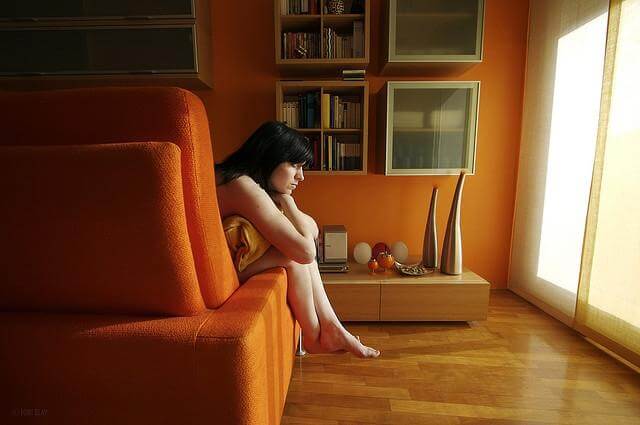 woman hugging pillow on the couch