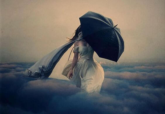 Kvinde går på skyer med paraply i hånden