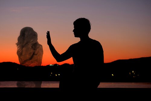 man reaching out for a silhouette of a woman