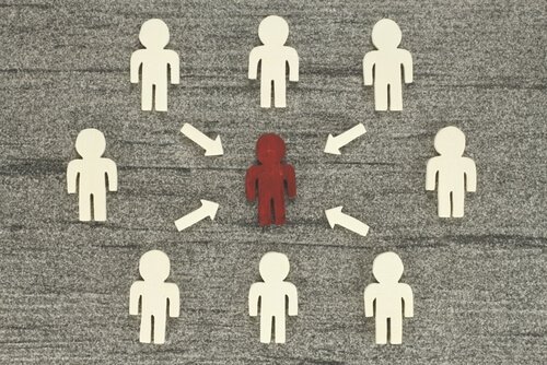 A crowd of paper cutouts is criticizing one red figured.
