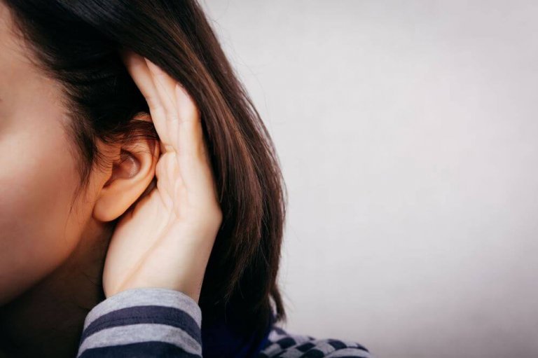 A woman is cupping her ear to hear the limits.
