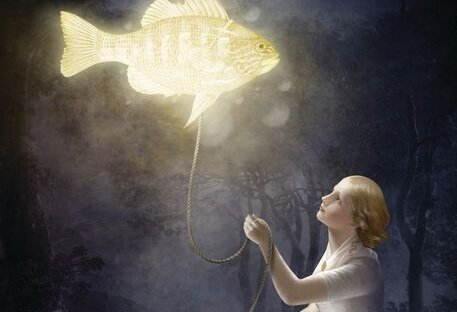 A girl has a glowing floating fish on a leash.