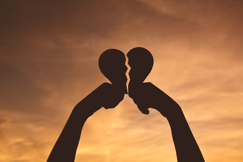 hands holding up broken heart