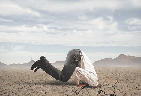 man with head stuck in the ground