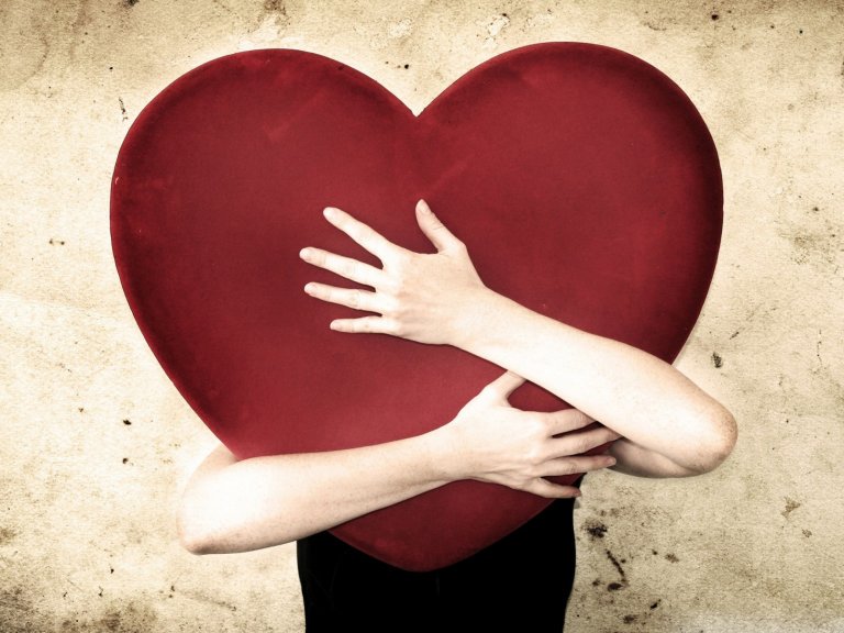 A person is hugging a giant heart.