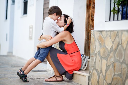A mother and a son are hugging forehead to forehead.