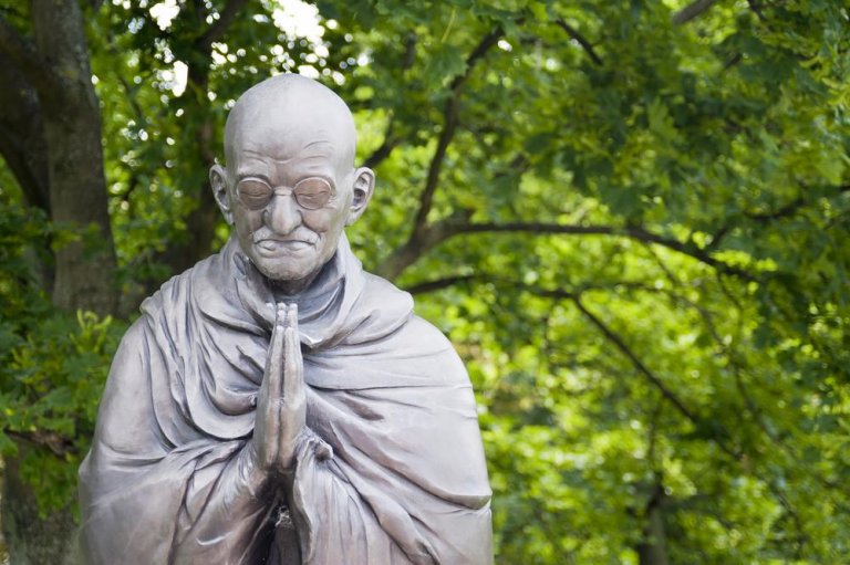 A statue of Gandhi praying.