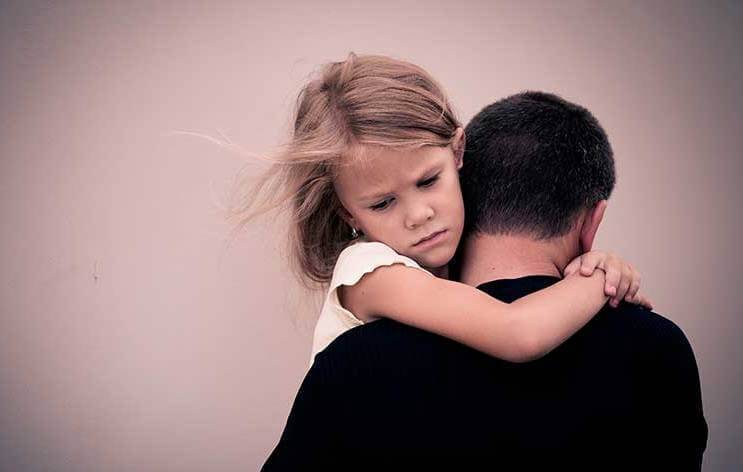 upset girl being carried by father