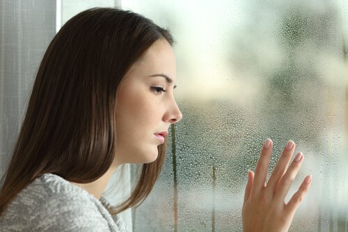woman staring out rainy window
