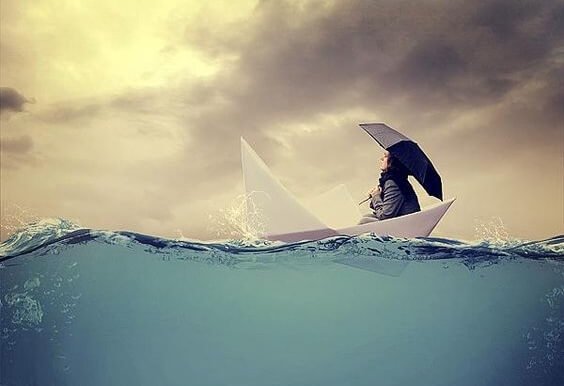 A woman with an umbrella is sailing in a paper boat.