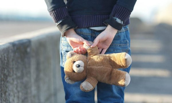 a victim of child abuse holding a teddy bear