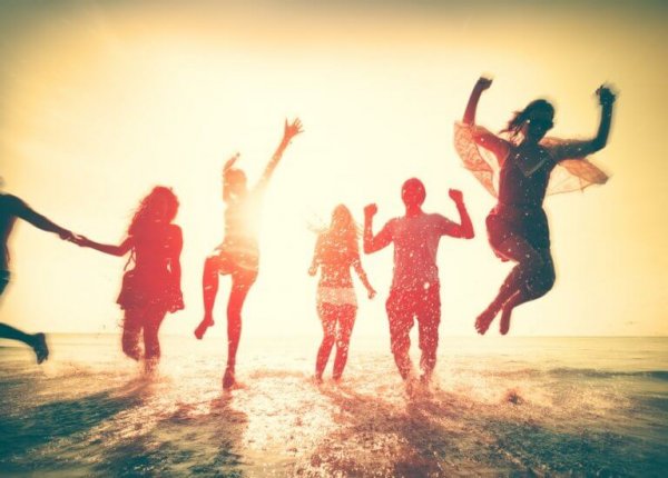 friends jumping happily in the waves