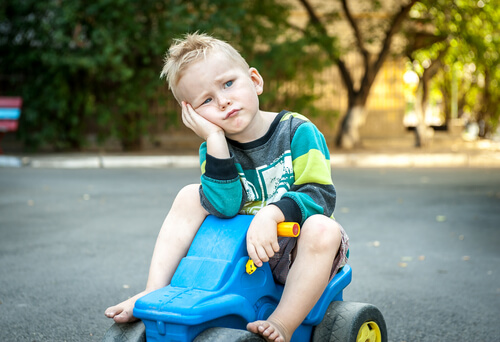 a bored little boy on a toy car
