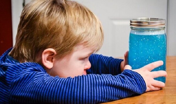 a child looking at a calm down jar