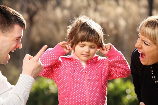 a little girl caught between parents arguing and yelling