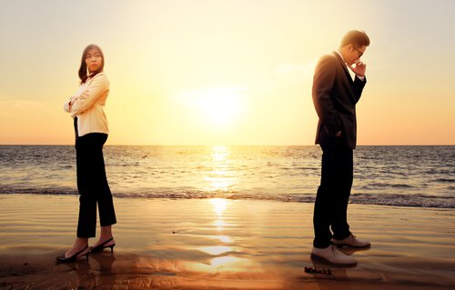 a couple fighting on the beach in formal clothes