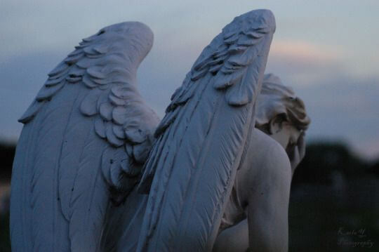 an angel statue looking depressed
