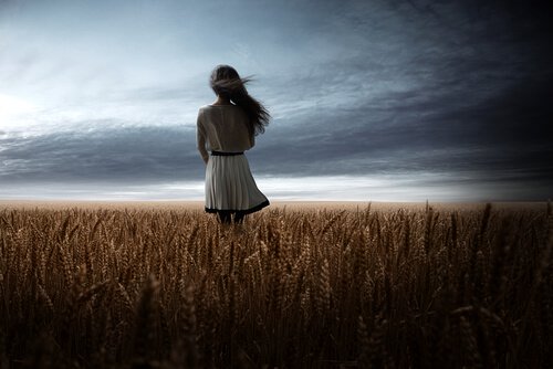 a girl in a field of wheat, pondering opportunities