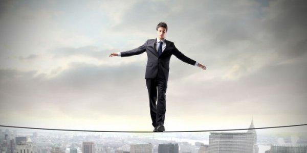 a man walking on a tightrope in a city