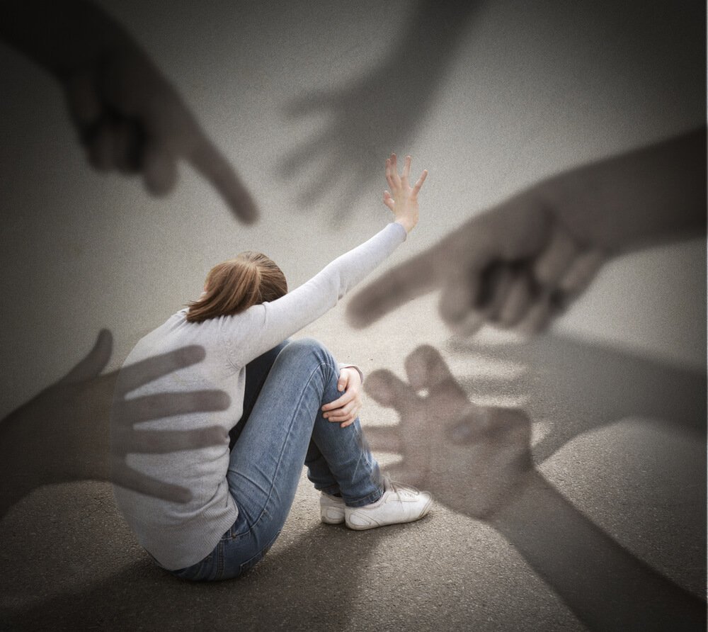 Many giant hands are pointing at a girl on the ground.