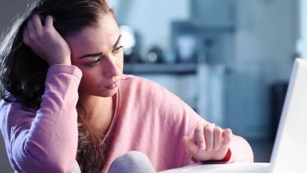 a sad teen at the computer