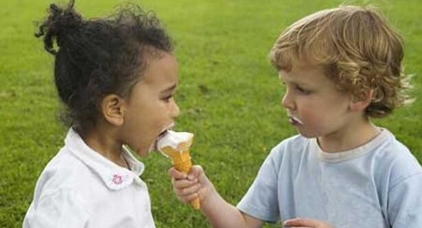 Two kids are sharing an ice cream cone and one is being a good person
