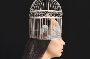 A woman is trapped inside a birdcage inside her mind.