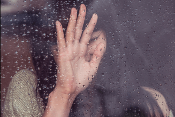 psychophysiological disorders: a woman crying at the rainy window