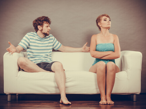 A couple having an argument on a couch.