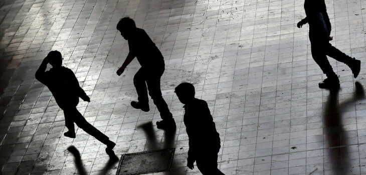 Black silhouettes running on the street.