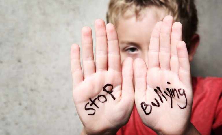 Boy with Stop Bullying written on his palms.