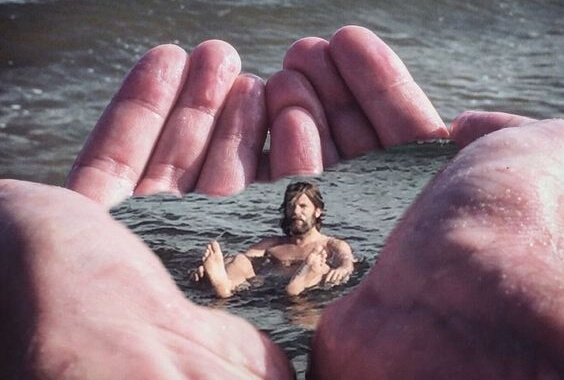 A man is floating within a pair of hans.
