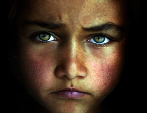 A sad child with light eyes.