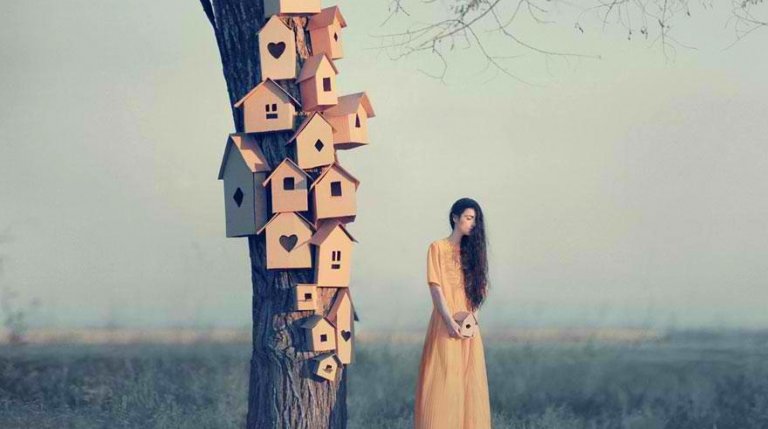 A woman next to many birdhouses.