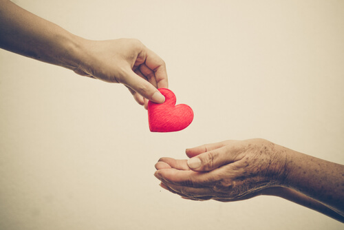 A person giving another a heart.