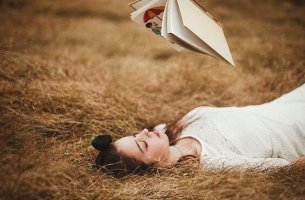 A bored girl is reading a book in her free time