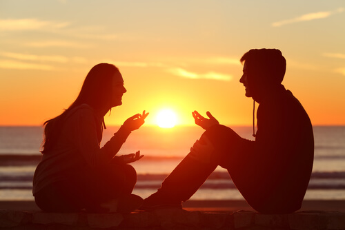 two friends chatting at sunset on the beach