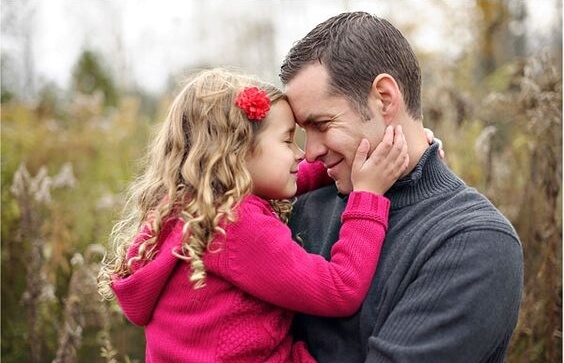 A little girl and her dad, face to face.